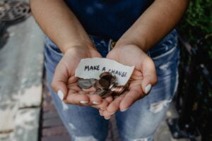 Žena drži kovanice i natpis napravi promenu kao ilustracija teksta o tome kako uštedeti više